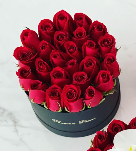 Rosas rojas caja circular negra.