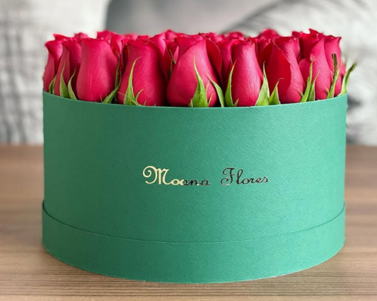 Rosas rojas en caja circular negra mate.