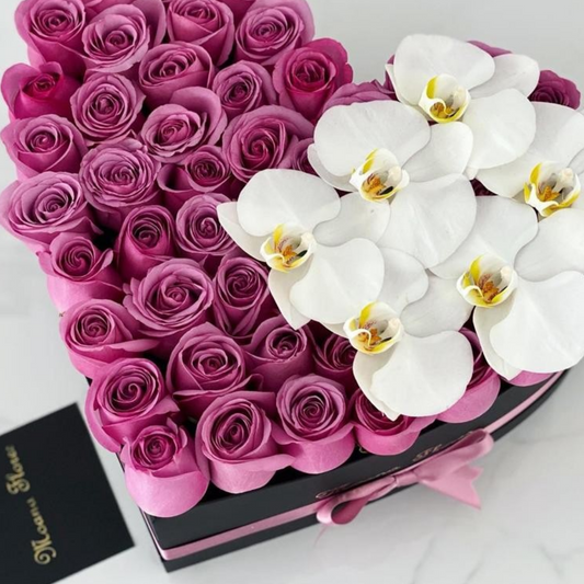 Rosas moradas con orquídeas blancas.