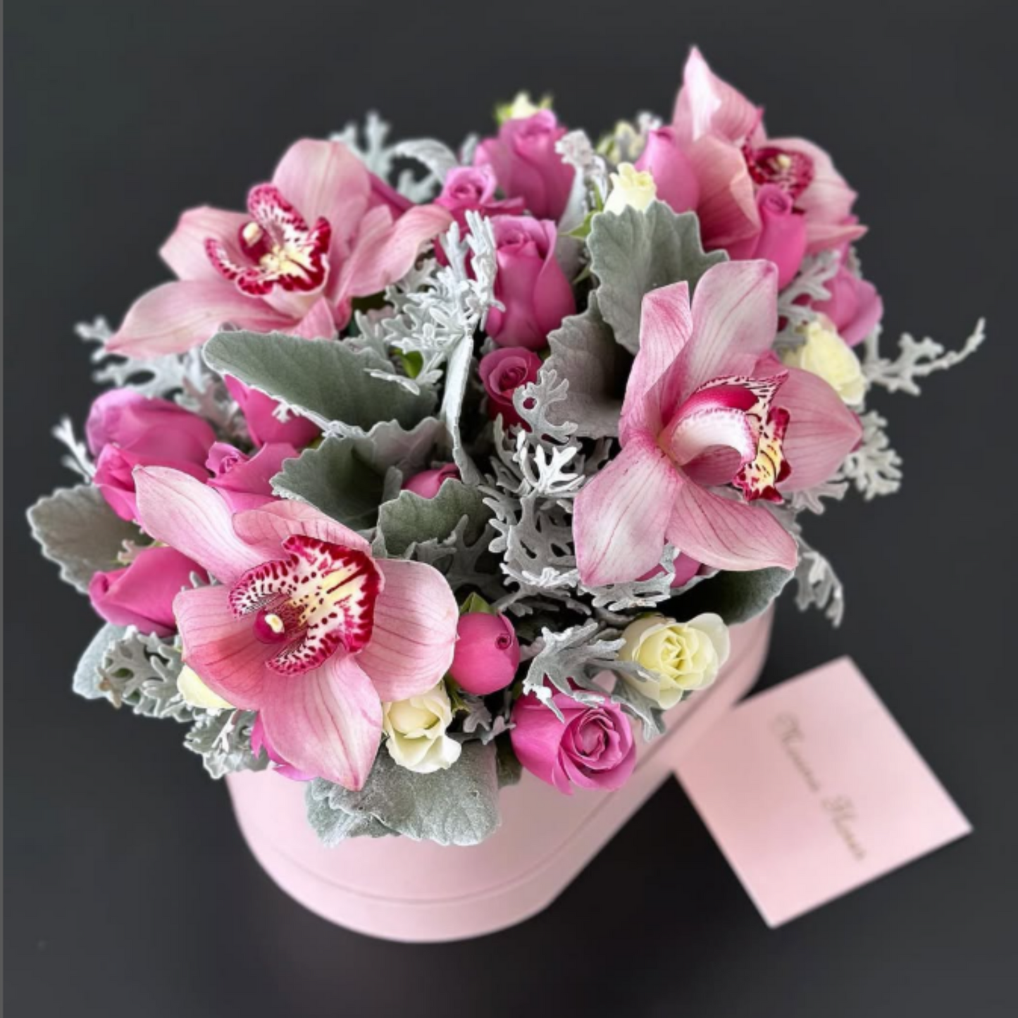 Blushera con rosas moradas con orquídeas vino y follaje.