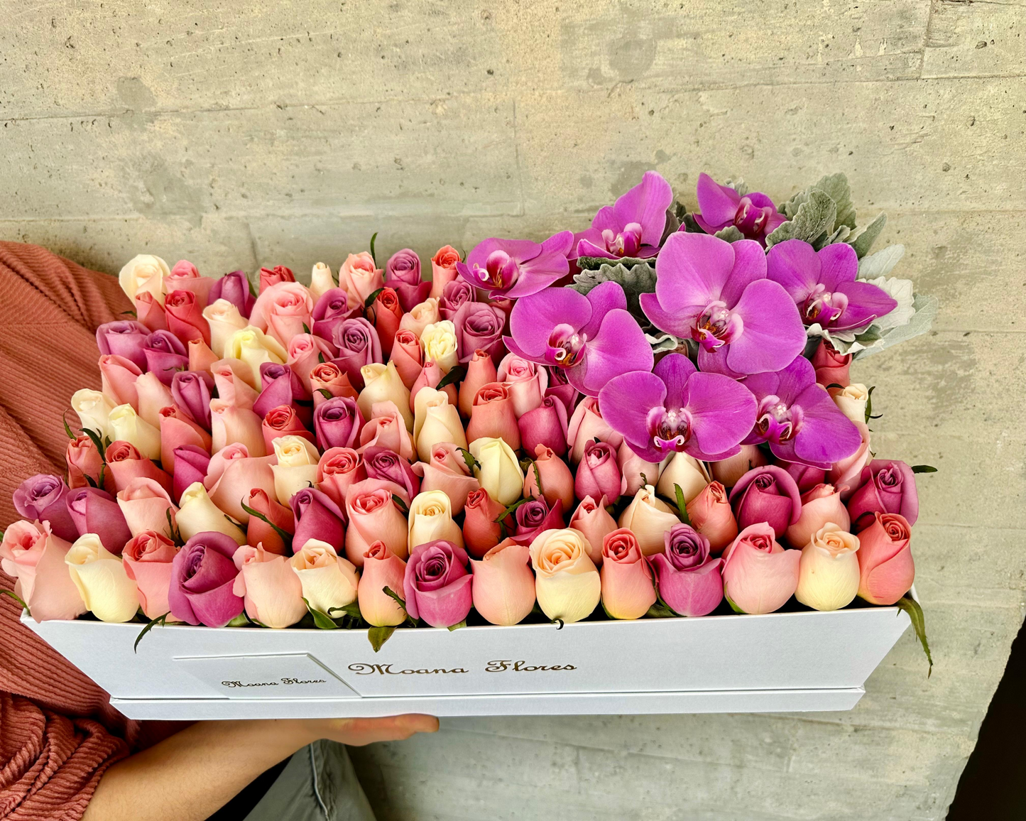 Rosas moradas, caricias, blancas, follaje con orquídeas moradas.