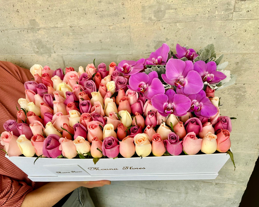 Rosas moradas, caricias, blancas, follaje con orquídeas moradas.