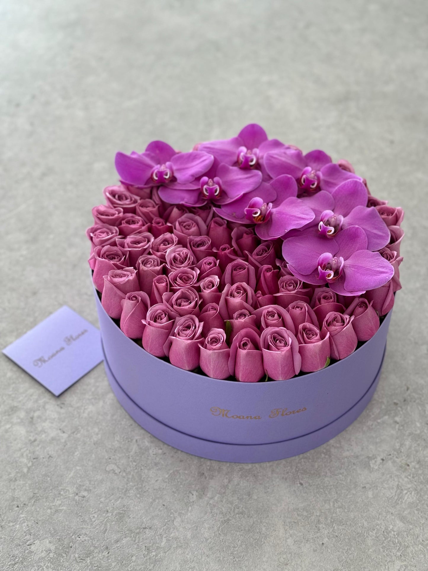 Rosas moradas con orquídeas moradas en caja morada