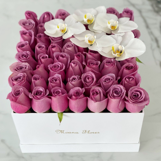 Rosas moradas con orquídeas blancas.