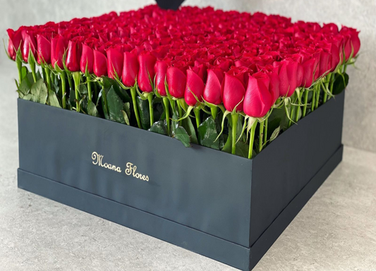 Rosas rojas con follaje en caja cuadrada grande negra