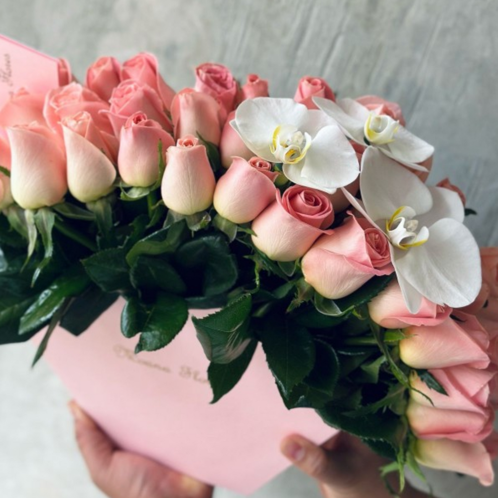 Rosas hermosas con follaje con orquídeas blancas.