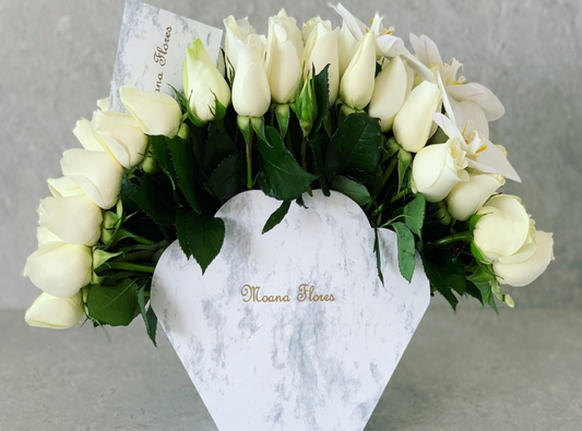 Rosas blancas con follaje y orquídeas blancas