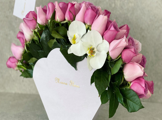Rosas moradas rosas nauticas con follaje y orquídeas blancas