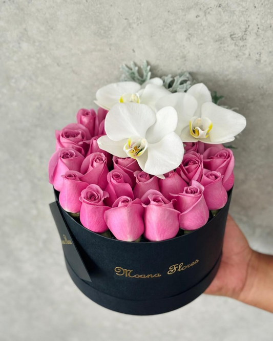 Rosas moradas con follaje y orquídeas blancas