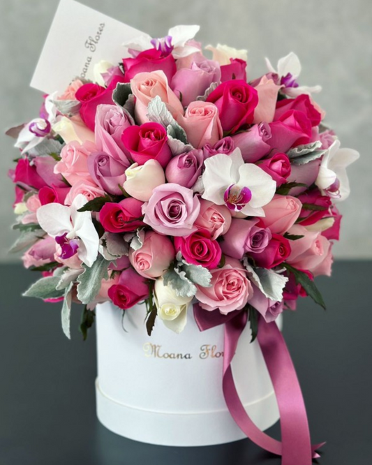 Domo de rosas moradas, caricias, fucsia, náuticas con orquídeas blancas y follaje.