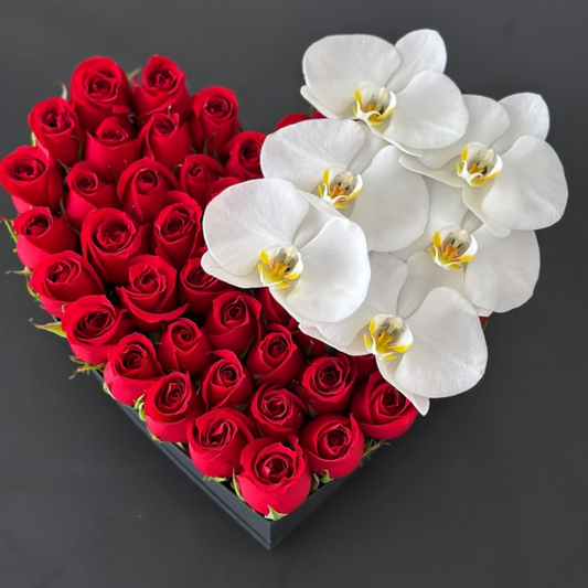 Rosas rojas con orquídeas blancas en caja de corazón negro regular