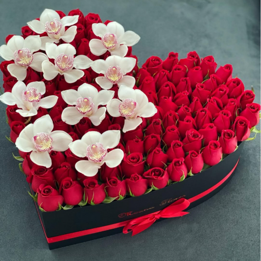 Rosas rojas con orquídeas blancas cymbidium en caja mediana negra con liston