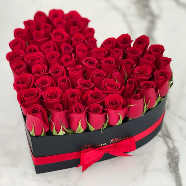 Rosas rojas en caja de corazón negro regular.