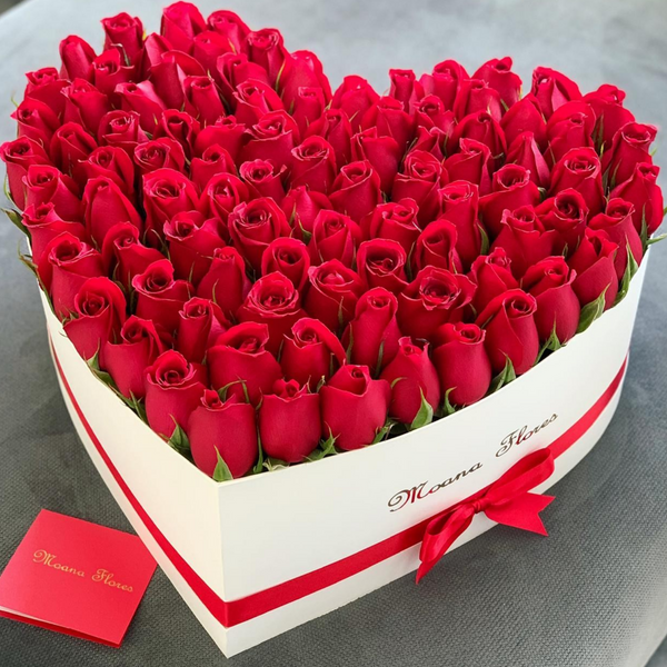 Rosas rojas en caja de corazón blanco intermedio.