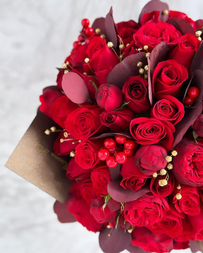 Domo rosas rojas con follajes cálidos.