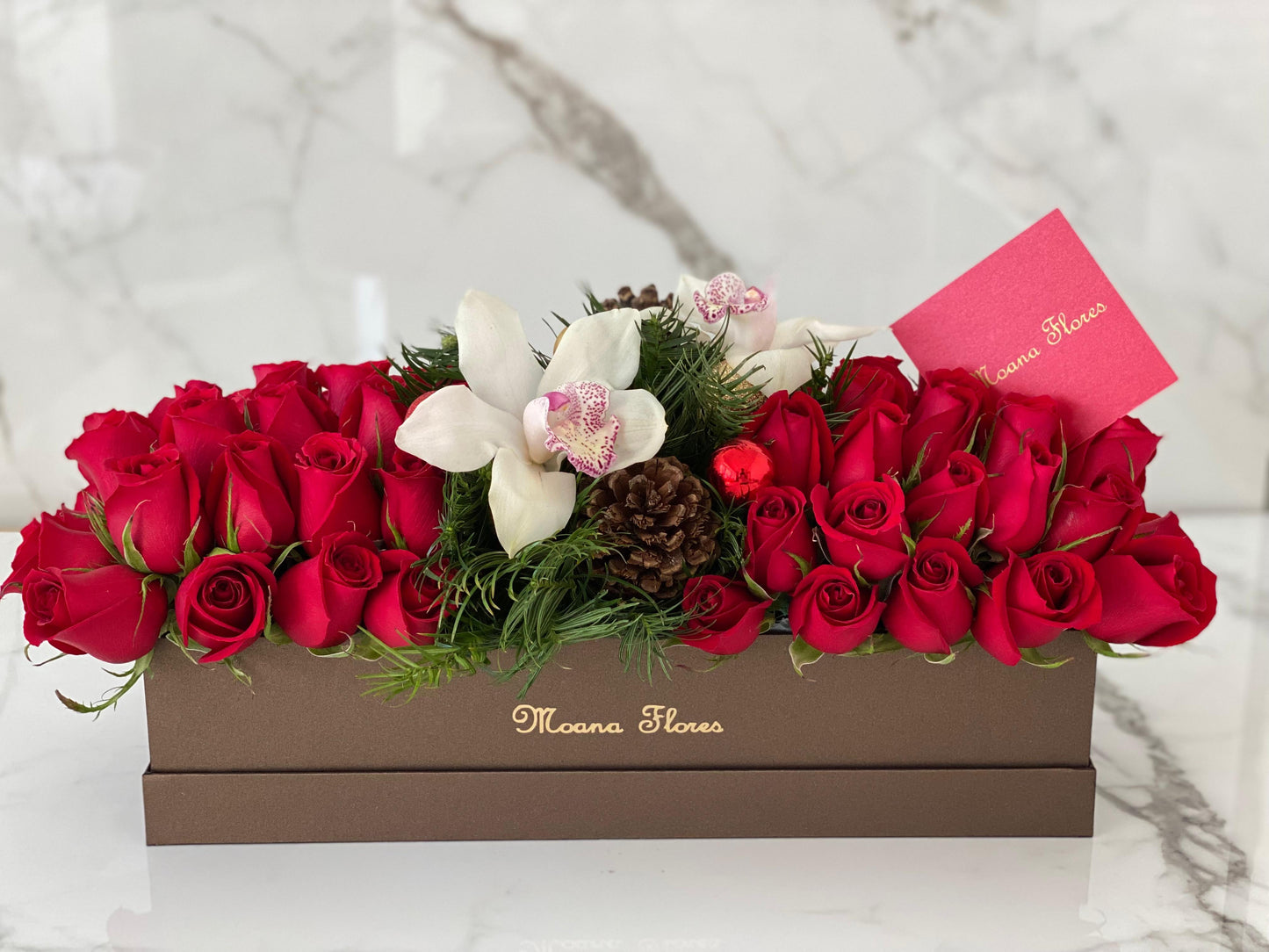 Rosas rojas, orquídeas blancas en caja marrón.