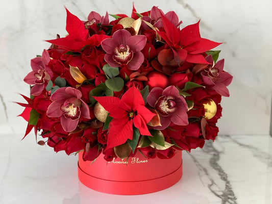 Domo premium de rosas rojas y flores de pascua en caja roja.