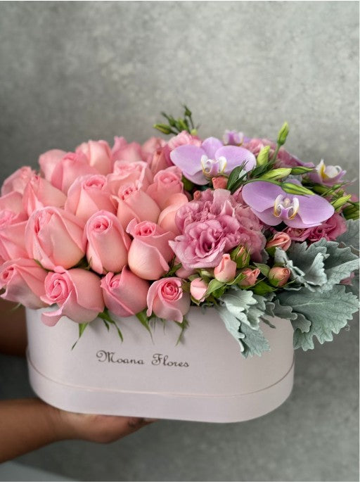 Blushera con rosas en tono rosa, lisianthus rosa y orquídeas lilas.
