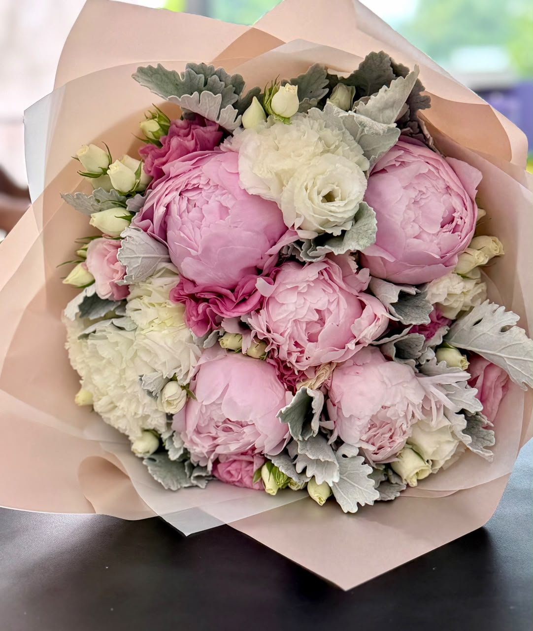Bouquet de peonias rosas con lisianthus rosa y follajes.