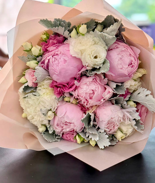 Bouquet de peonias rosas con lisianthus rosa y follajes.